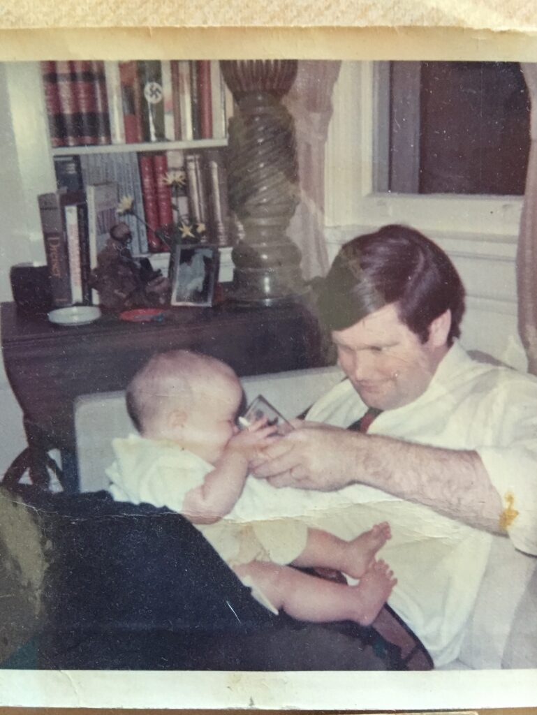 Warren Hinckle giving baby daughter Pia a drink from his beer (1965).